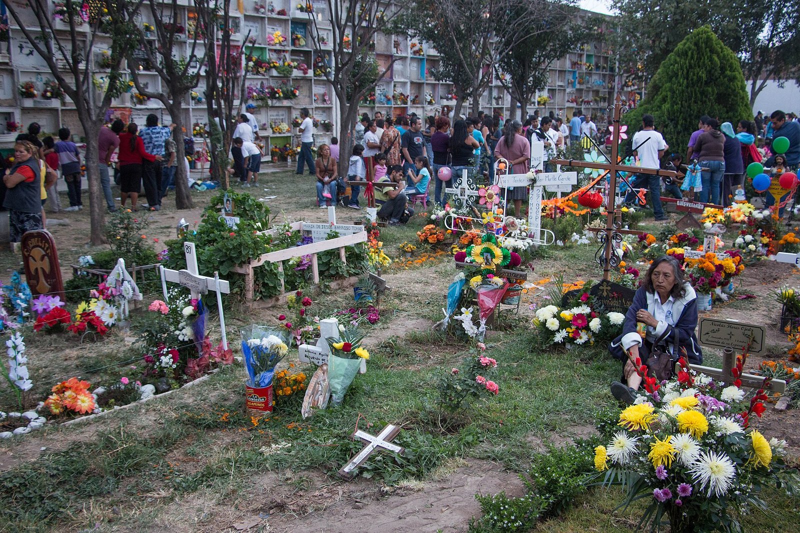 Visitantes en un panteón mexicano durante el Día de Muertos